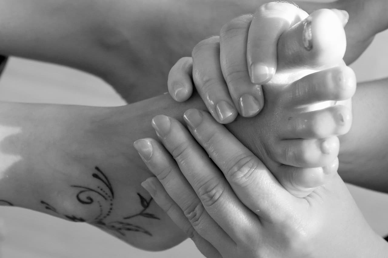 Hands massaging a foot during a pedicure, in black and white